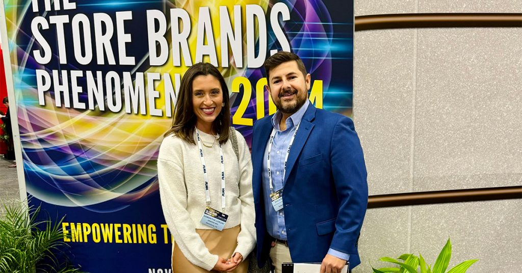 Two people standing in front of a sign that says The Store Brands Phenomenon